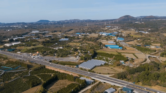 도로와 언덕이 있는 넓은 농지