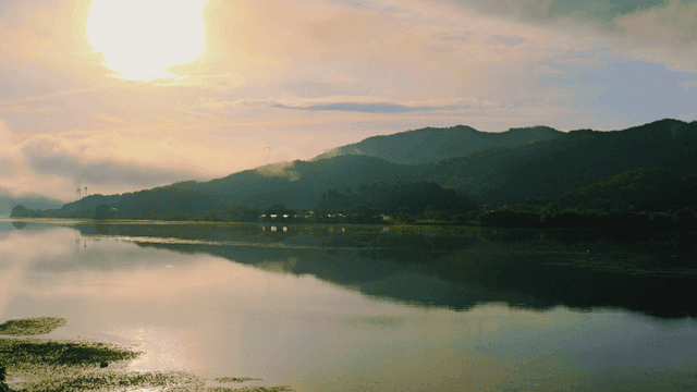 Serene lake with mountains under sun