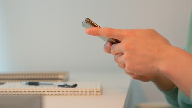 Person using smartphone at a desk