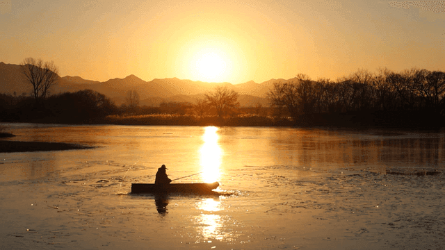 Silhouette of person riding ferry on river at sunrise