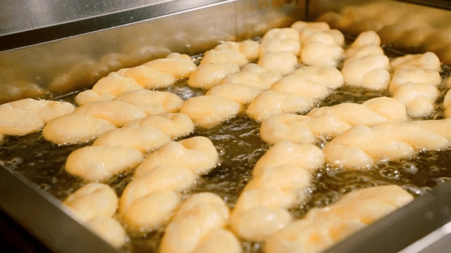 뜨거운 기름에 튀겨지는 꽈배기 도넛