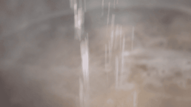 Salt being poured into a boiling pot