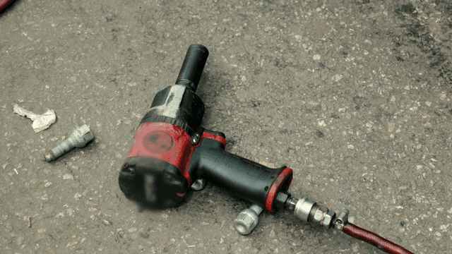 Air impact wrench on asphalt ground