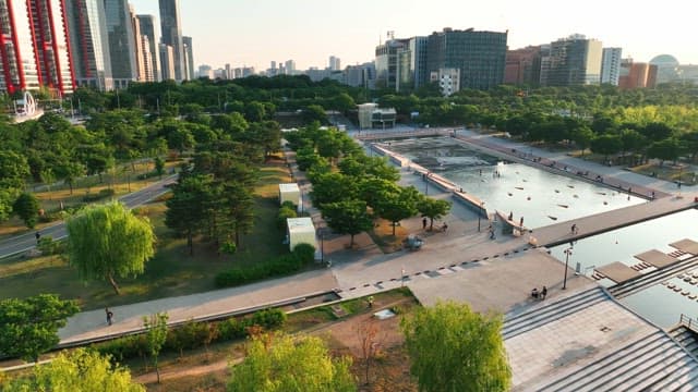 Modern urban riverside park with fountain in square