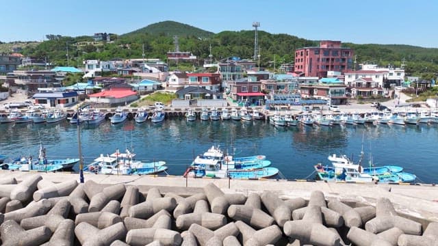 Coastal village with fishing boats and breakwaters