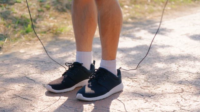 Person skipping rope on a sunny path