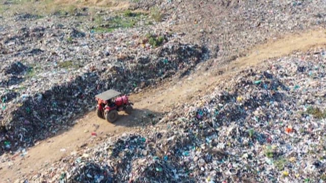 Tractor Navigating Through Massive Landfill