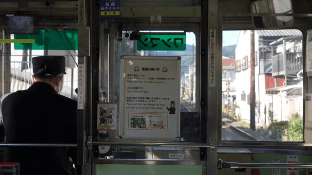 A locomotive driver driving through a quiet Japanese village