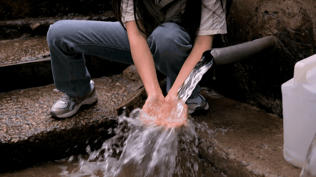 Person washing hands in flowing water