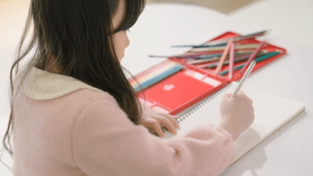 Child drawing with colored pencils