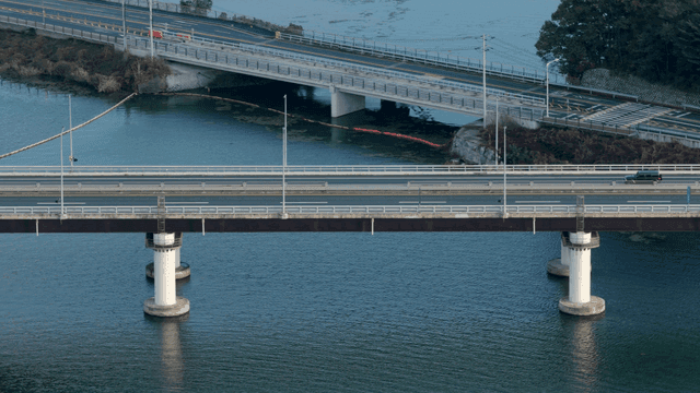 강 위의 다리를 달리는 자동차들