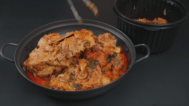 Pork backbone stew being transferred to pot