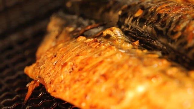 Grilled fish sizzling on a grill