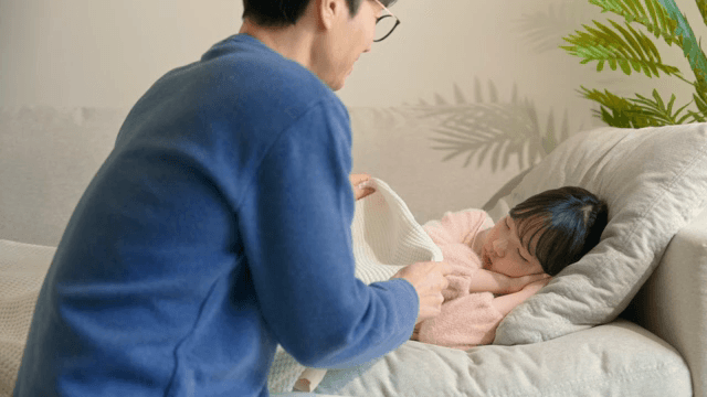 아빠가 잠든 아이를 부드럽게 쓰다듬는 모습