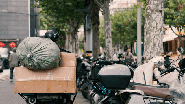 길거리에서 물건을 가득 싣고 가는 오토바이 운전자