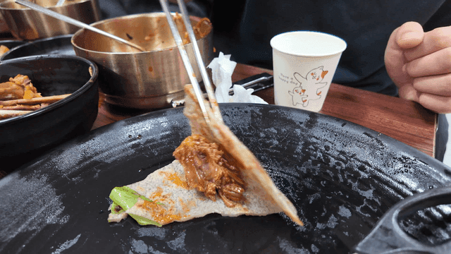 Pork ribs wrapped in buckwheat pancakes and eaten with chopsticks