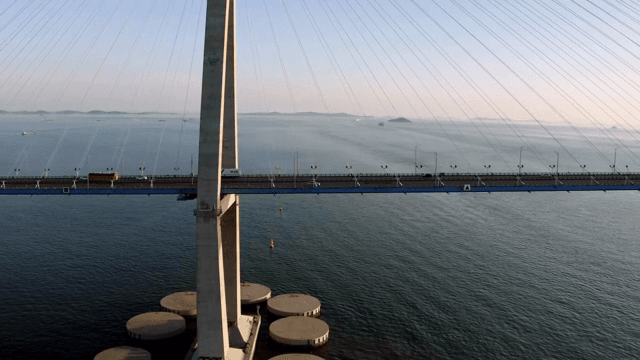 차량이 있는 고요한 바다 위의 다리