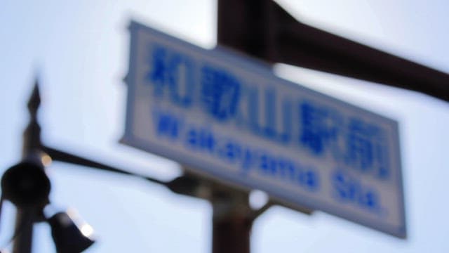 햇빛 속 와카야마 역 표지판