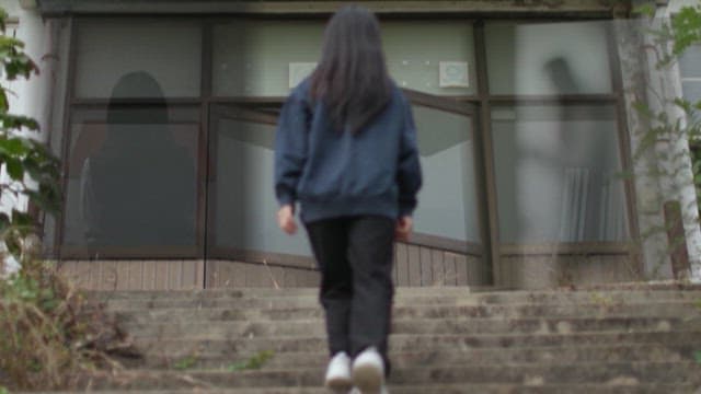 Young Woman Walking Up Stairs to Building