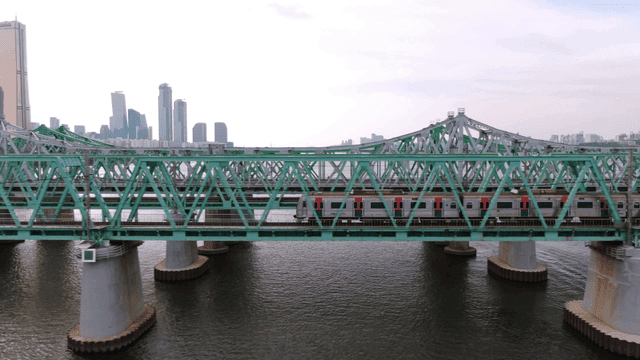 Train crossing a bridge in a cityscape