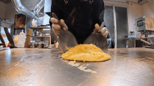 Preparing omelet on a hot griddle by chef