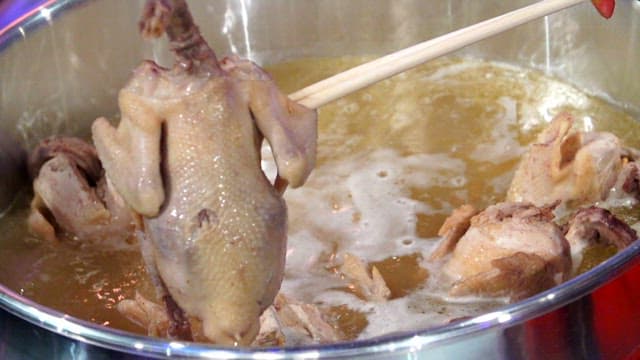 큰 냄비에서 건져올린 닭고기 한 조각