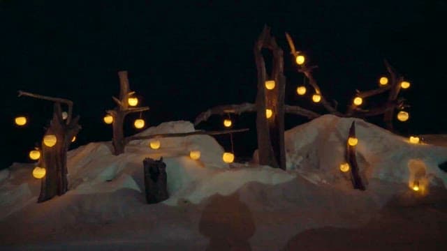 Snowy Landscape with Illuminated Lanterns at Night