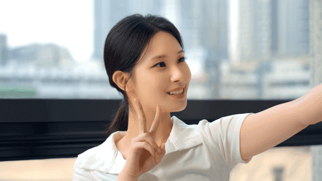 창가에서 브이 포즈를 취하는 젊은 여성의 옆모습