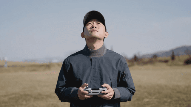 Man operating a drone in an open field