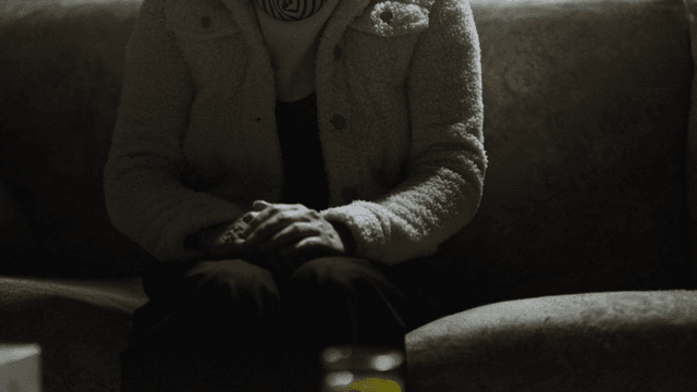 Middle-aged woman sitting on sofa and talking