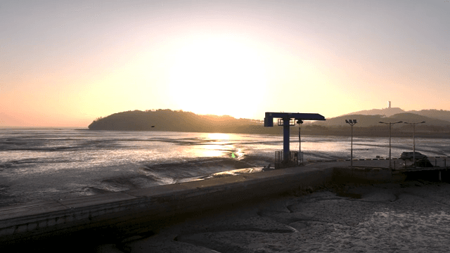 멀리 언덕이 보이는 고요한 바다의 일몰