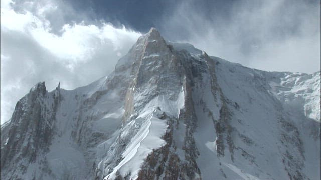 Climbers ascending a snowy mountain peak