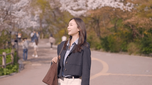 Woman walking through a park and looking at flowers