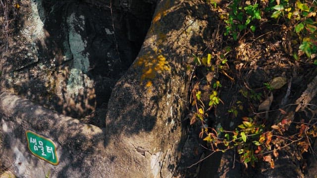 바위로 만들어진 오래된 샘물터의 초록색 이름표