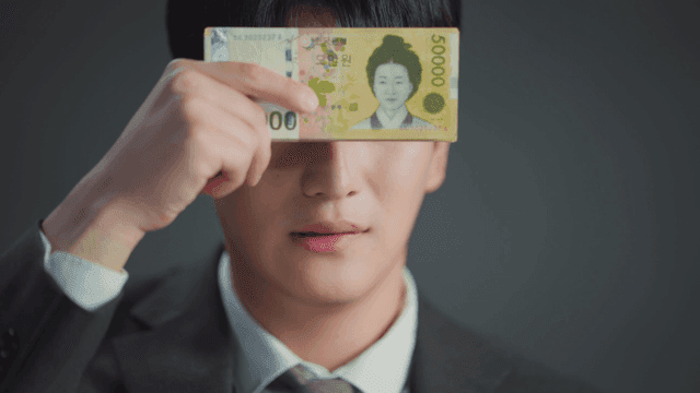 돈으로 얼굴을 가리며 상반된 표정을 보이는 남자