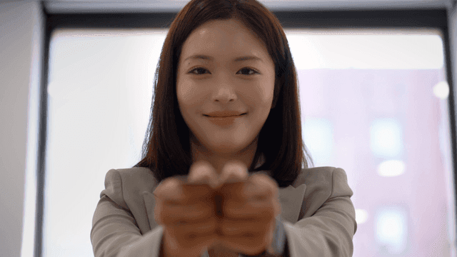 Female office worker in suit holding business card