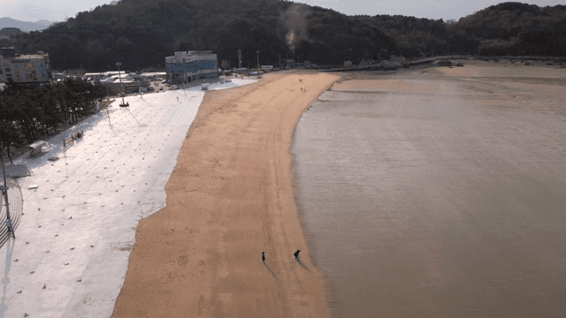 몇몇 사람들이 걷고 있는 조용한 해변