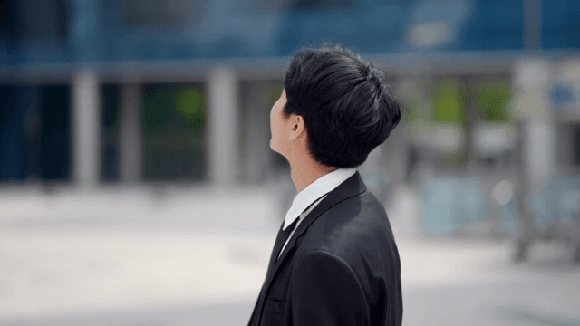 Smiling office worker leaves the building with a happy expression