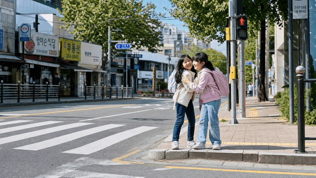 Two girls laughing at a crosswalk