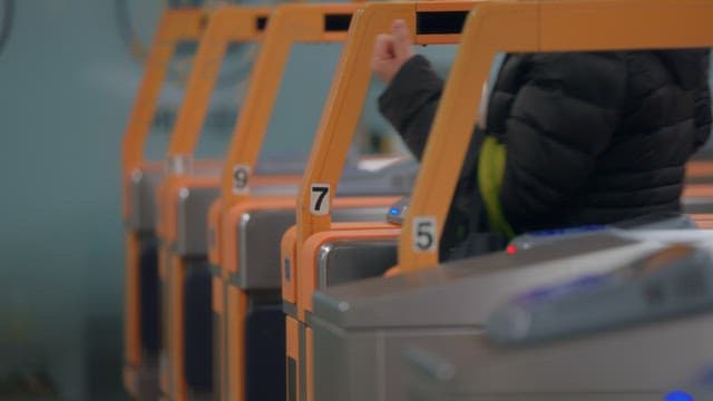 People passing through subway turnstiles