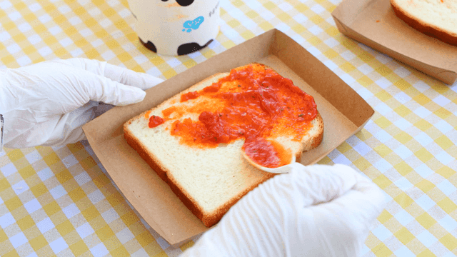 Spreading tomato sauce on bread