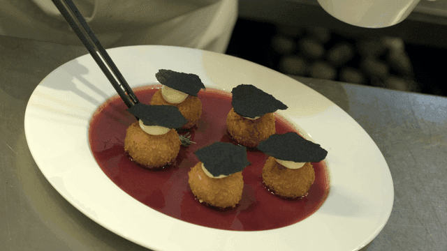 Chef elaborately decorates fried dish.