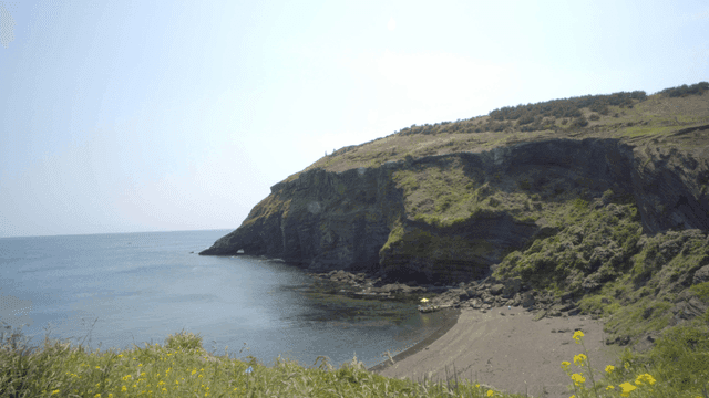 Serene coastal cliff with clear waters