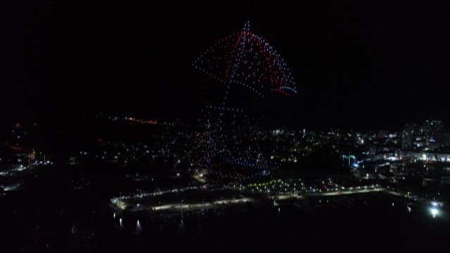 도시 위 야간 드론 라이트 쇼