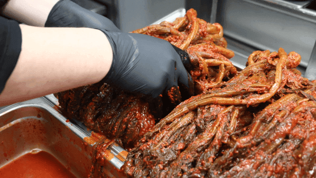 Gatgimchi being filled onto tray in kitchen