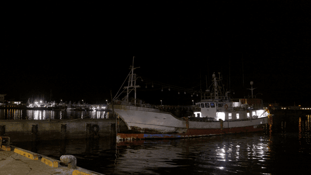 Fishing boat docked at night in a harbor