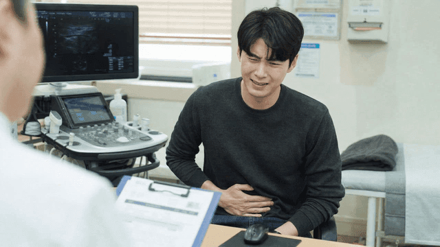 Male patient with abdominal pain consulting doctor at clinic