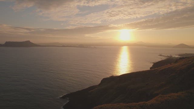 Sunset over the ocean with distant islands