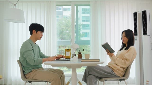 Two people talking while looking at a laptop in the living room at home during the day