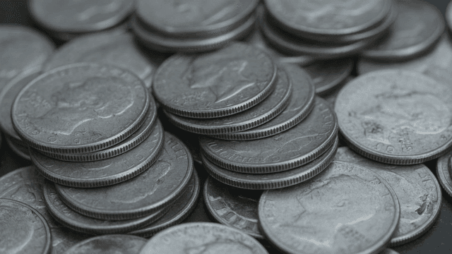 Piles of silver coins stacked layer upon layer.